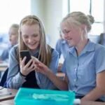A new Kansas law bars students from accessing phones, earbuds and smartwatches all school day, while one parent group is pushing for tighter iPad limits
