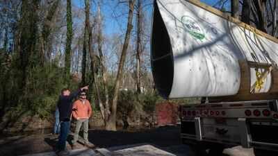 Atlanta reused a nearly 7,000-pound wind turbine blade as a 50-foot pedestrian bridge; the retired Colorado blade now carries walkers through Beaverbrook Park