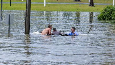 An Australian TV reporter was filming floods when he spotted a sinking four-wheel drive, swam out with a bystander and forced open a rear door to rescue the driver moments before the vehicle disappeared underwater
