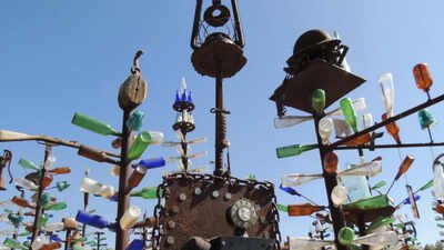 California cement worker Elmer Long turned discarded bottles and scrap metal into a desert art forest; as Route 66 turns 100, his two-acre ranch has 200 trees, 1,000+ bottles and visitors from around the world